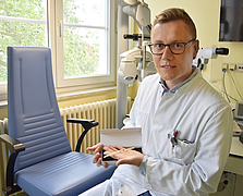 Prof. Tobias Brockmann im Behandlungszimmer hält ein Stent in den Händen