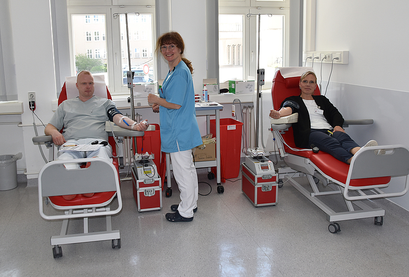 Auf zwei Liegen liegen ein Mann und eine Frau, die gerade Blut spenden. In der Mitte steht eine Krankenschwester. Die Universitätsmedizin Rostock setzt zahlreiche Maßnahmen im Sinne der Nachhaltigkeit um. Dazu gehören die Bereiche Umwelt, Soziales und Governance.