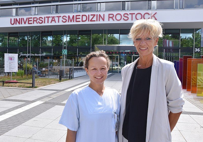 Zwei Ärztinnen stehen vor der Haupteingang der Unimedizin Rostock. 