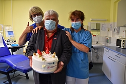 Eine Torte für das Blutspendeteam: v. l. Schwester Denys, Spender Klaus-Dieter Kramp und Schwester Gaby im Raum für die Thrombozytenspende 