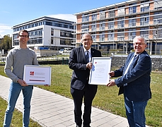 Prof. Wolfgang Schareck (Mitte, Universität Rostock) erhält von Prof. Steffen Emmert und Dr. Lars Böckmann (links, Universitätsmedizin Rostock) die Ehrenmitgliedsurkunde des NZPM.
