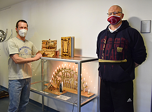 Zwei Männer mit Holzkunstwerken