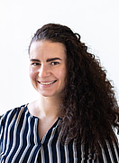 Porträt einer Frau vor einer modernen Fensterfront