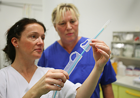 Zwei Mitarbeiterinnen beim Vorbereiten eines Katheters