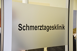 Eingangsschild an einer Tür mit dem Text Schmerztagesklinik