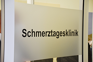 Eingangsschild an einer Tür mit dem Text Schmerztagesklinik