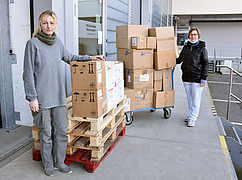 Die Leiterin des Medizinproduktelagers Sabrina Nagel (rechts) übergibt die Medizinprodukte an Liudmyla Lauf.