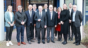 Gruppenbild: Die Teilnehmer des Besuchs stehen vor dem Haupteingang des Instituts