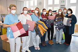  Stationsleiterin Janine Schreiber (2. v. l.) und ihre Kolleginnen freuen sich über die großartige Kissenspende, die Lehrerin Peggy Tetzlaff (r.) mit ihren Schülerinnen Josephine (5.v.r.), Lina (4.v.r) und Hannah (3.v.r.), die fleißig mitgenäht haben, übergibt. 