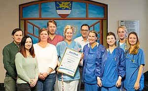 Mehrere Menschen in Arbeitskleidung stehen nebeneinander
