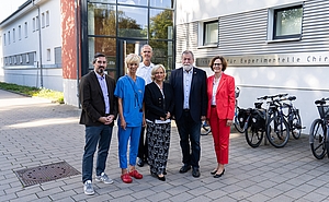 Gruppenbild von 6 stehenden Personen vor einem Gebäude.