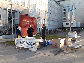 Mitarbeiter vor der Klinik an einem Stand zum Spendensammeln