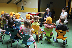 Prof. Dr. Steffen Emmert vermittelt den Kindern der Kita Gewächshaus wie Sonnenschutz richtig geht.