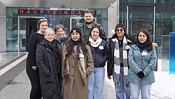 8 Personen stehen lächelnd vor dem Haupteingang der Universitätsmedizin Rostock