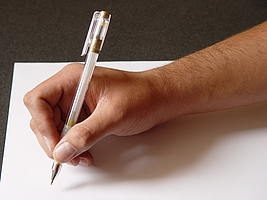 Hand hält Stift über weißem Blatt Papier