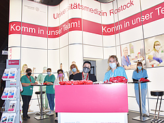Am Stand der Unimedizin Rostock informieren Kollegen aus der Pflege über den Berufseinstieg im Gesundheitswesen.