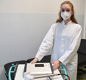 Stella Hofmeyer zeigt ein Kaltplasmagerät, das für die Hautbehandlung verwendet wird.