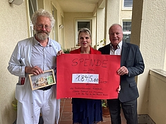 prof. Classen, ein Mann und eine Frau mit einem Spendenscheck in der Hand