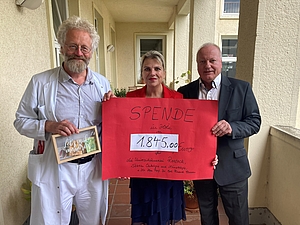 prof. Classen, ein Mann und eine Frau mit einem Spendenscheck in der Hand