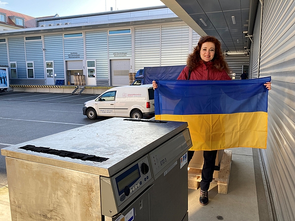 Junge Frau mit ukrainischer Flagge auf einer Laderampe