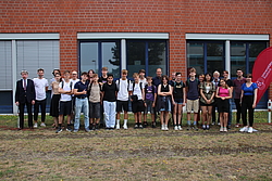 Gruppe von Schülern vor einem geklinkerten Gebäude