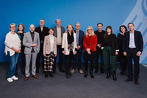 Eine Gruppe von Menschen steht zusammen und schaut nach vorne