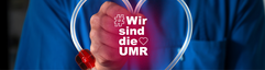 Nahaufnahme eines Mitarbeiters in blauer Arbeitskleidung hält einen transparenten Schlauch in Herzform in Richtung Kamera. In der Mitte ist der Schriftzug "#Wir sind die UMR" in weiß mit rotem Schein platziert.