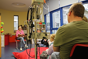 Die jungen Patienten und ihre Eltern lauschen der Geschichte von Lotte