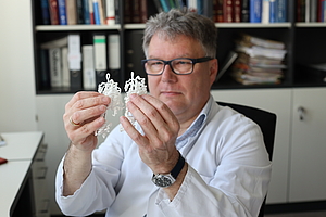 AG Intestinale Mukosafunktion Ene Person mit kleinen Modellen in der Hand