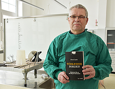 Fred Zack hält Buch in der Hand