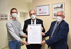 Prof. Wolfgang Schareck (Mitte, Universität Rostock) erhält von Prof. Steffen Emmert und Dr. Lars Böckmann (links, Universitätsmedizin Rostock) die Ehrenmitgliedsurkunde des NZPM.