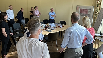 Mehrere Menschen vor einem Flipchart in einer Besprechung