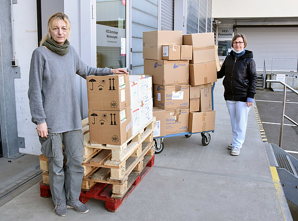 zwei Frau mit Kartons mit Hilfsgütern