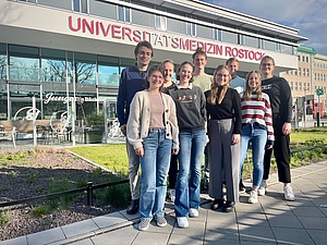 Das Team der Fachschaft steht vor dem Haupteingang