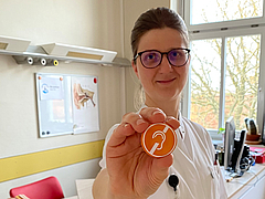 Dr. Wilma Großmann zeigt Pin