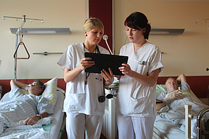 Zwei Schwestern im Patientenzimmer studieren Krankenakte