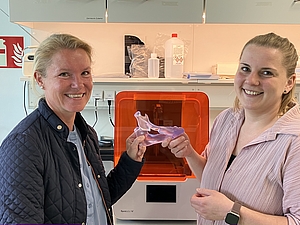 Zwei Frauen im Labor halten in der Mitte ein Modell an den Händen.