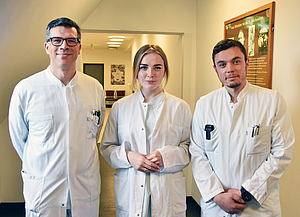 Prof. Freiman, Alona Kolbunova und Dr. Dubinski stehen in Reihe in einem Flur