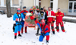 Team der Feuerwehr-Superhelden steht im Hof der Kinderklinik