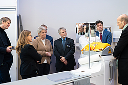 8 Personen stehen in einem Kreis und hören gespannt einander zu