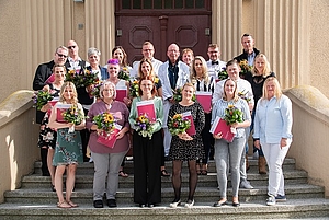 Gruppe von menschen mit Blumen auf Treppe