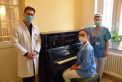 Arzt und Schwestern neben einem Klavier