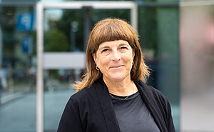 Porträt einer Frau vor einem modernen Klinikeingang