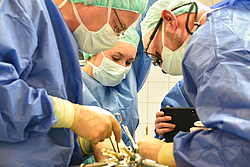 Thoraxchirurg Dr. Rolf Oerter (v.l.), Medizinstudentin Antonia Bollensdorf und Gefäßchirurg Dr. Justus Groß am OP-Tisch
