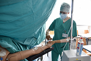 ATA steht neben einem Patienten und legt Zugang