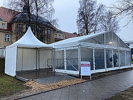 Weißes Zelt vor Klinikgebäude