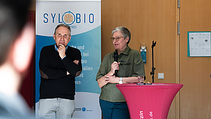 2 Personen auf einer Bühne bei einer Präsentation