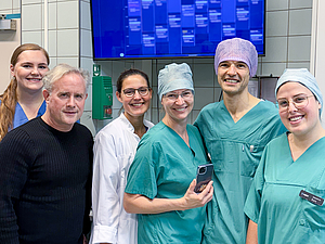 6 Personen stehen nebeneinander und strahlen vor Freude.