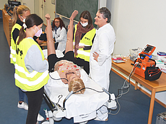 Dr. Gernot Rücker (r.) leitet die Studentinnen bei der richtigen Therapie an der Simulationspuppe an.