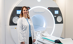 Dr. Ann-Christin Klemenz steht vor einem CT mit ausgefahrener Liege